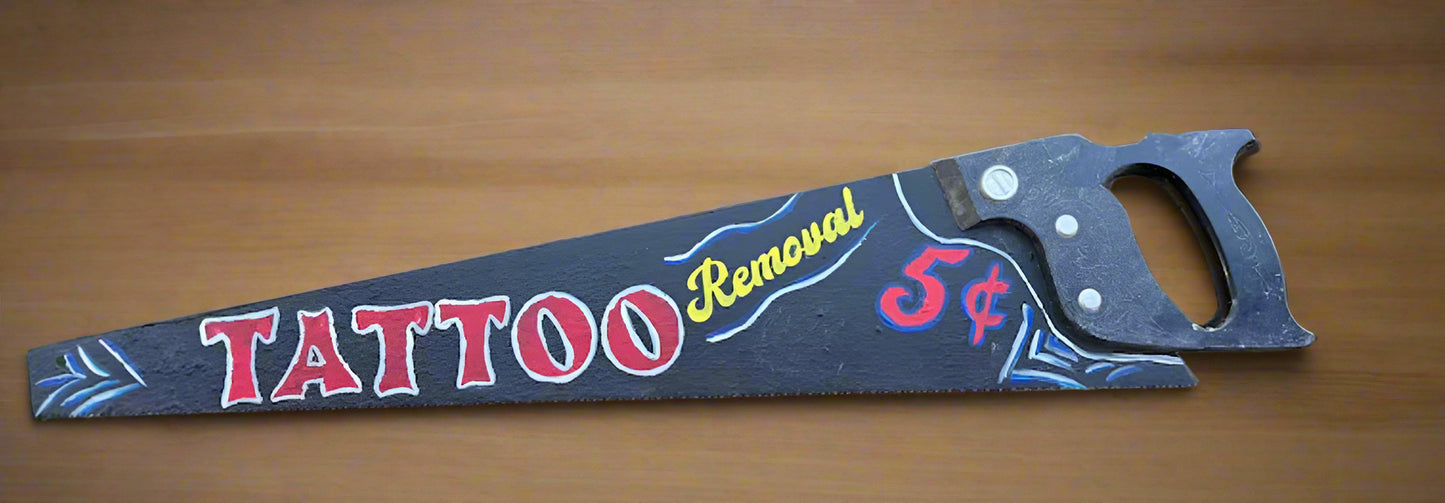 Decorative saw with ‘Tattoo Removal’ hand painted on it.