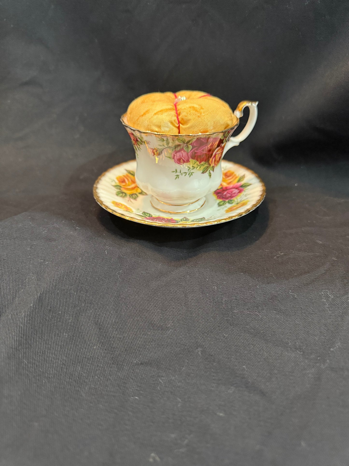 "Handmade quilted pin cushion with decorative fabric and secure pin storage"