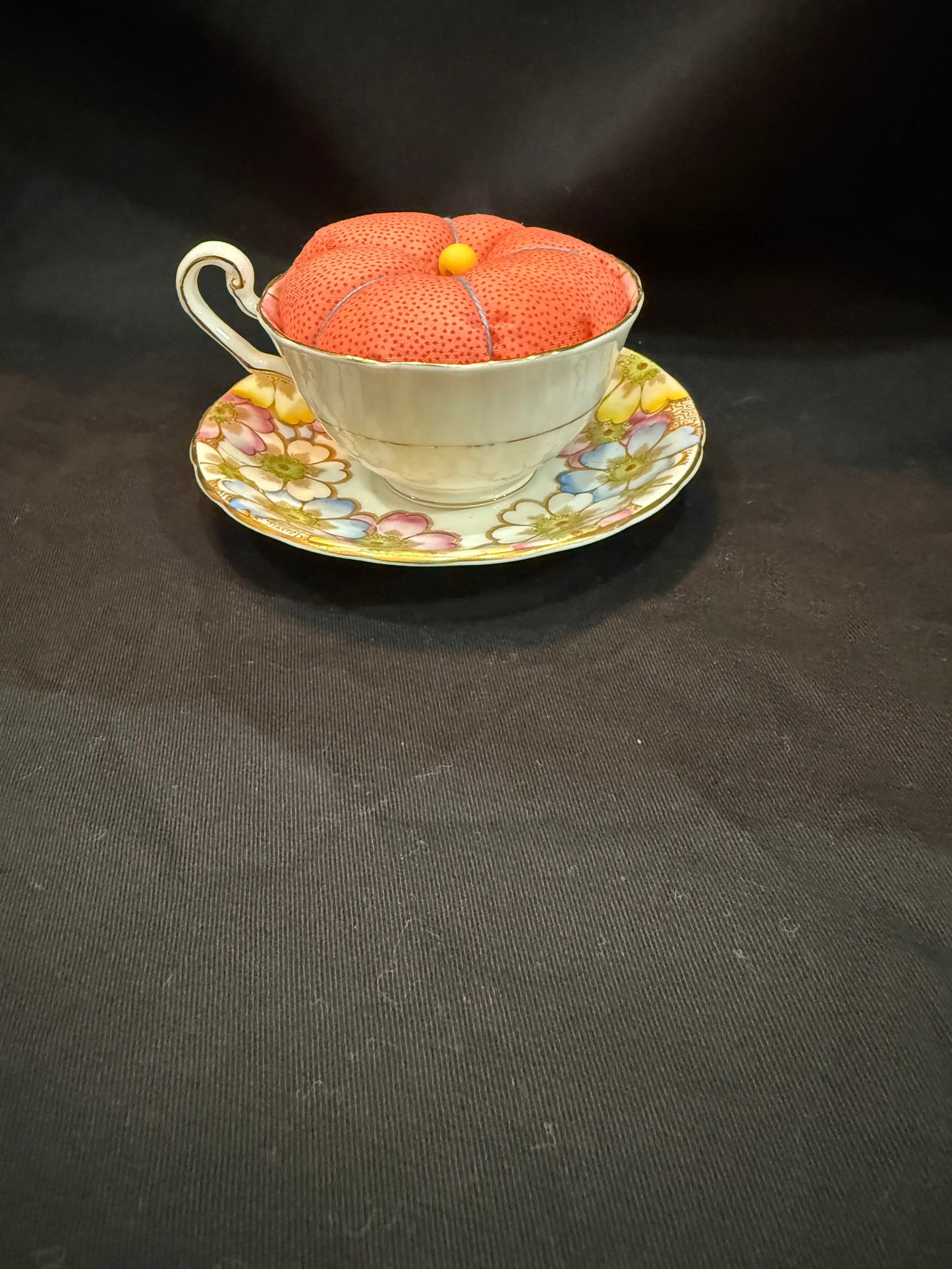 "Handmade quilted pin cushion with decorative fabric and secure pin storage"