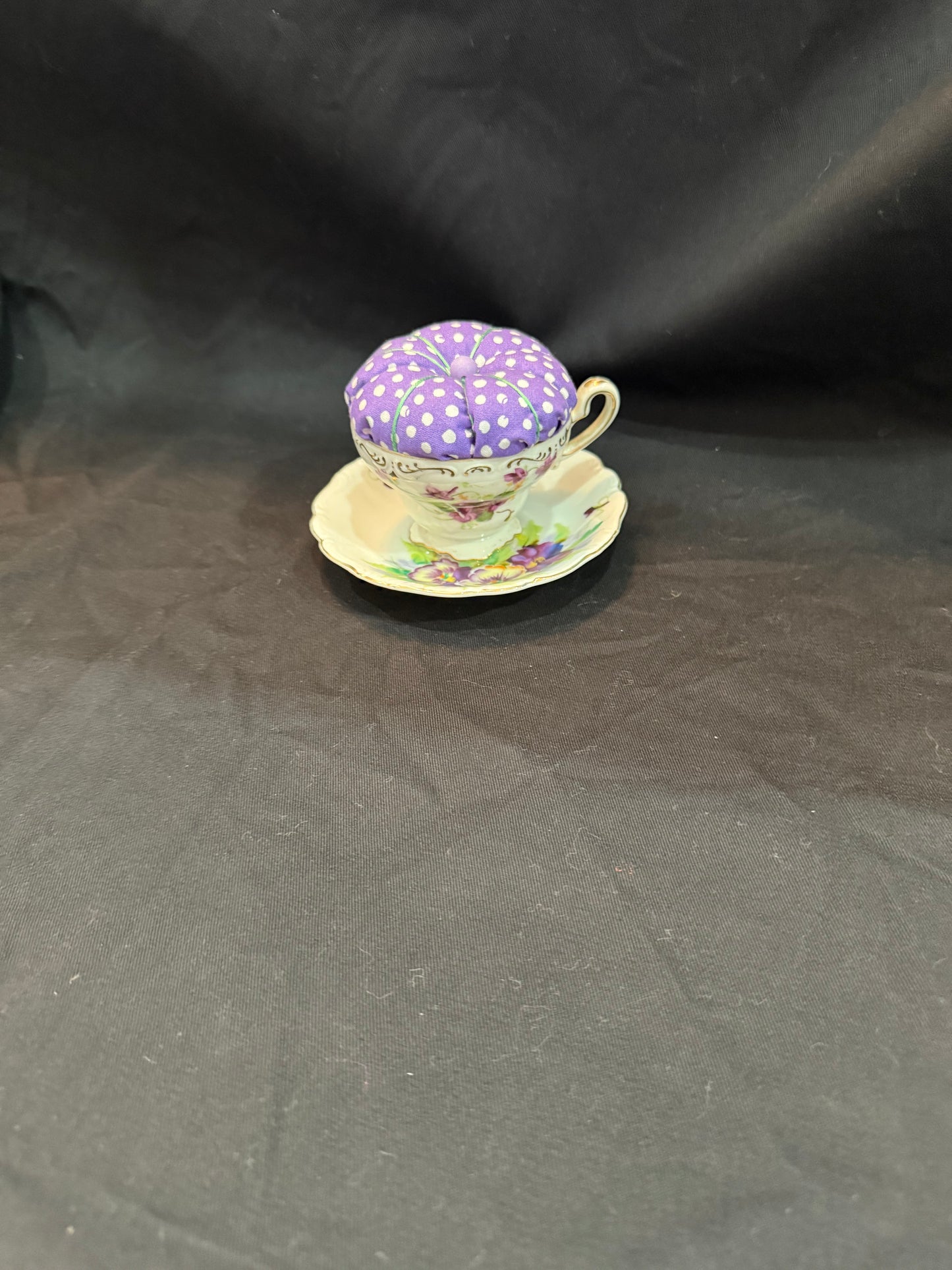 "Handmade quilted pin cushion with decorative fabric and secure pin storage"