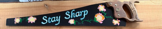 Decorative saw with floral design and 'Stay Sharp' hand painted on
