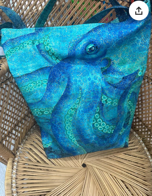 "Handmade quilted tote bag with fabric handles and decorative stitching"
