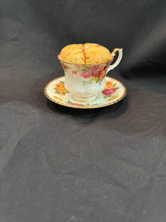 "Handmade quilted pin cushion with decorative fabric and secure pin storage"
