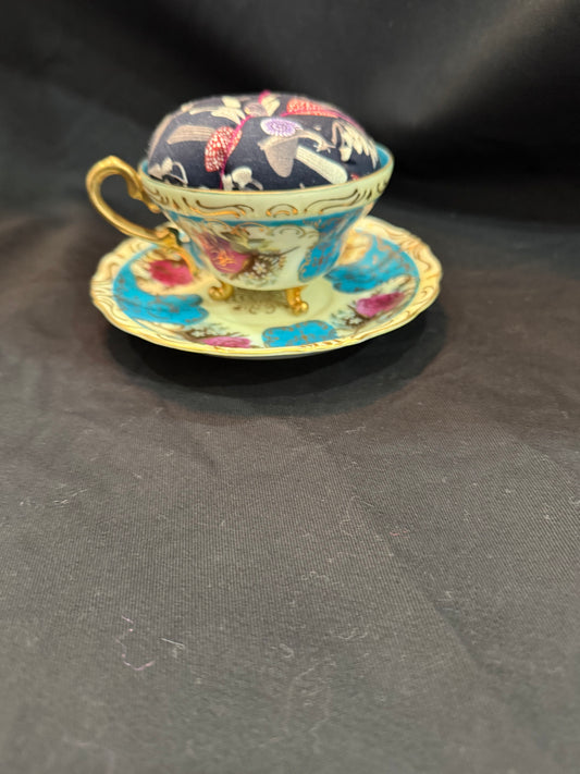 "Handmade quilted pin cushion with decorative fabric and secure pin storage"
