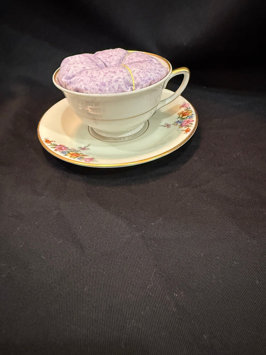 "Handmade quilted pin cushion with decorative fabric and secure pin storage"
