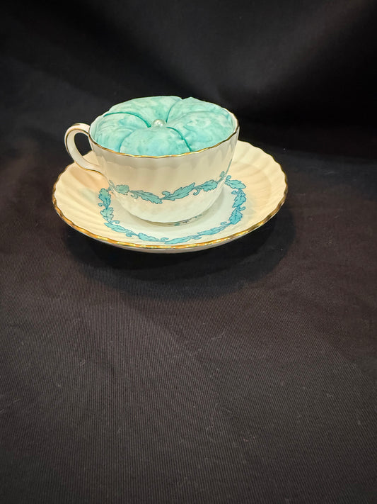 "Handmade quilted pin cushion with decorative fabric and secure pin storage"
