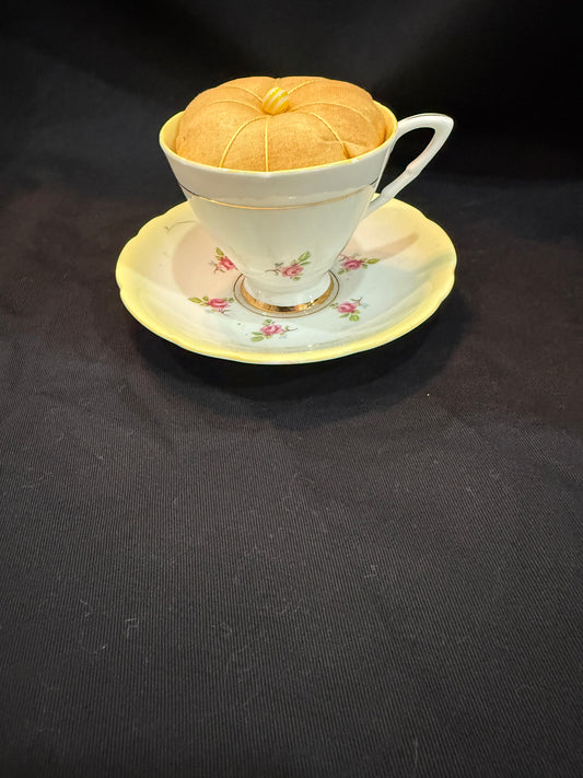 "Handmade quilted pin cushion with decorative fabric and secure pin storage"

