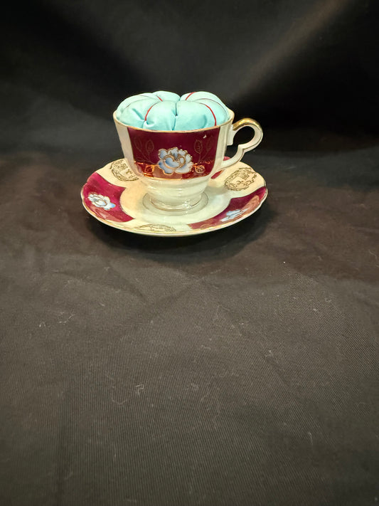 "Handmade quilted pin cushion with decorative fabric and secure pin storage"
