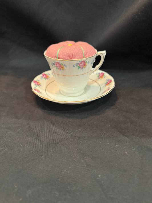 "Handmade quilted pin cushion with decorative fabric and secure pin storage"
