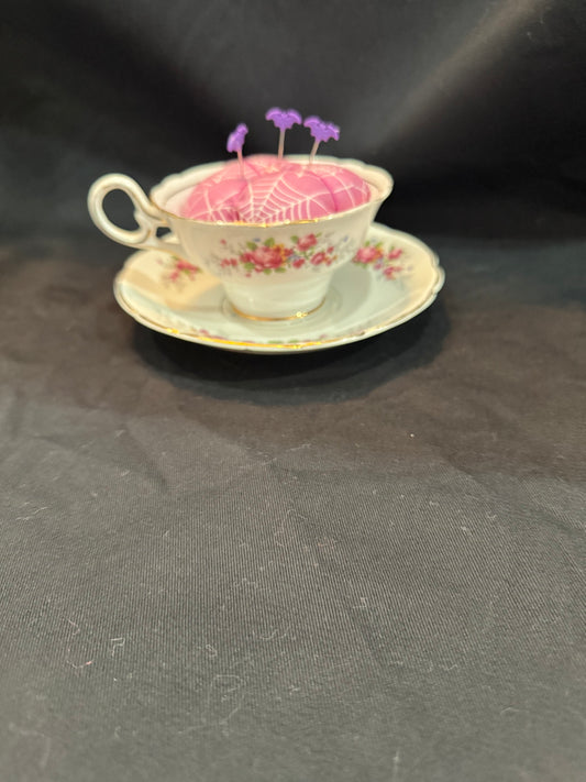 "Handmade quilted pin cushion with decorative fabric and secure pin storage"
