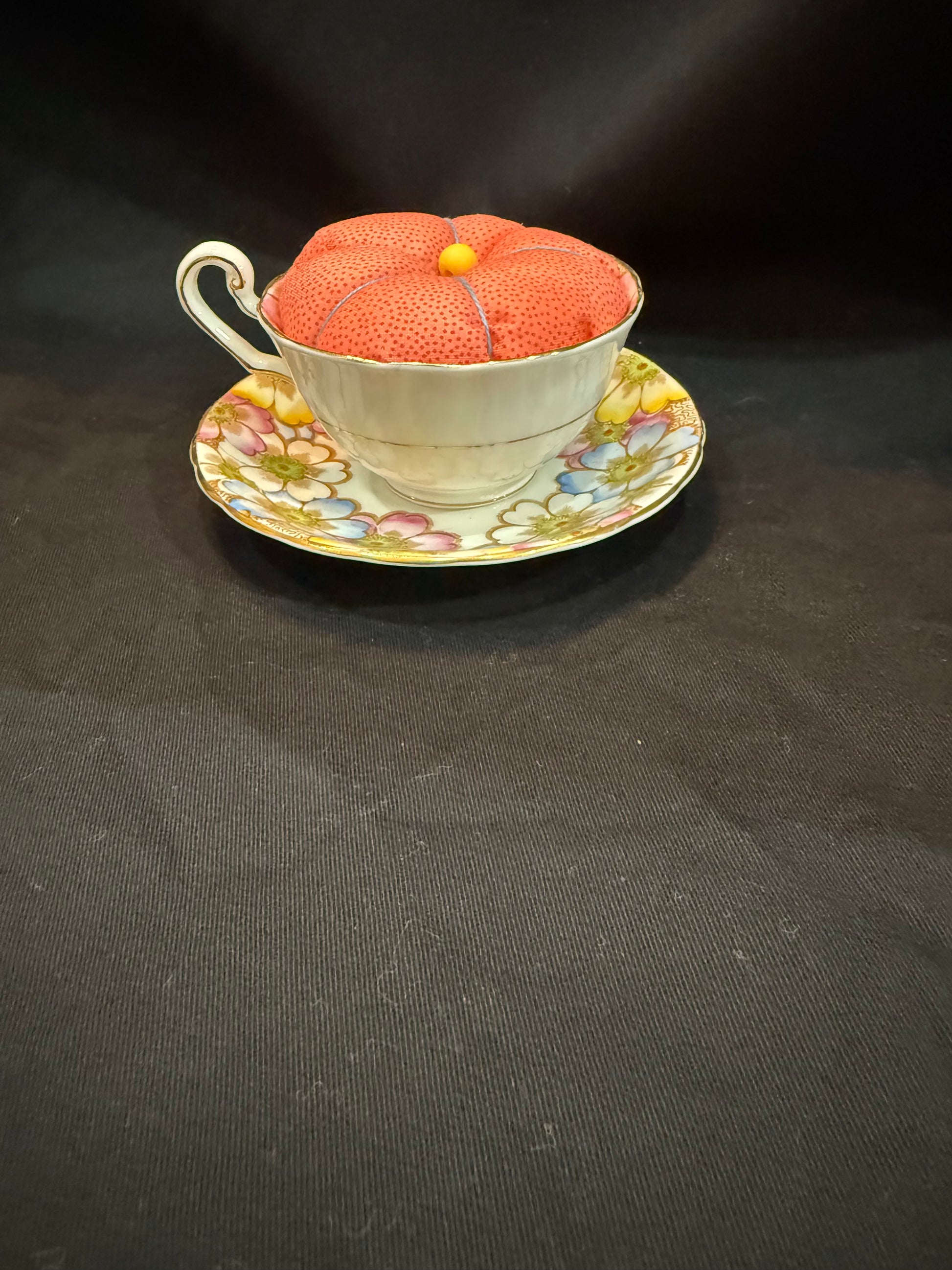 "Handmade quilted pin cushion with decorative fabric and secure pin storage"
