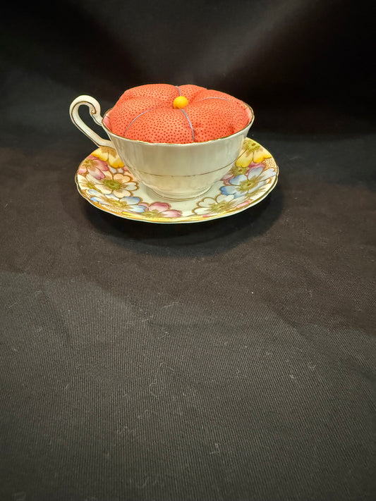 "Handmade quilted pin cushion with decorative fabric and secure pin storage"
