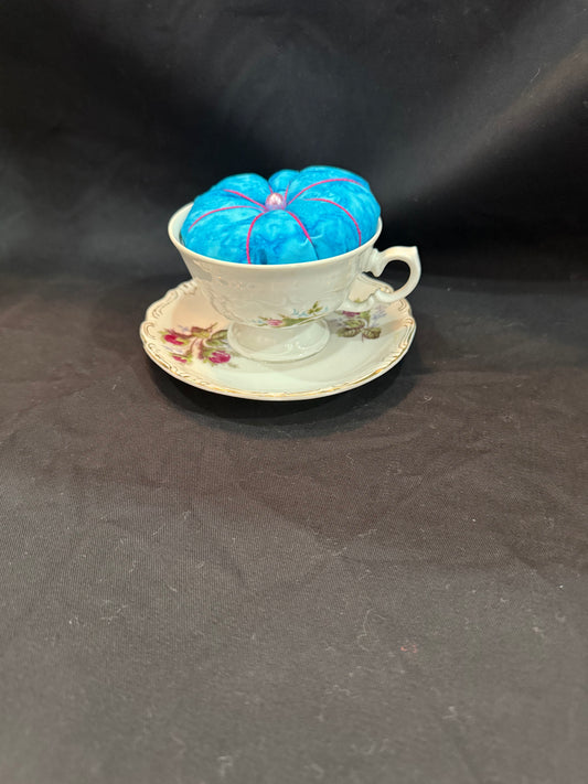 "Handmade quilted pin cushion with decorative fabric and secure pin storage"
