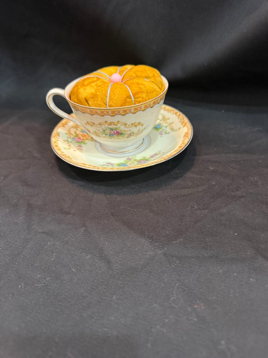 "Handmade quilted pin cushion with decorative fabric and secure pin storage"
