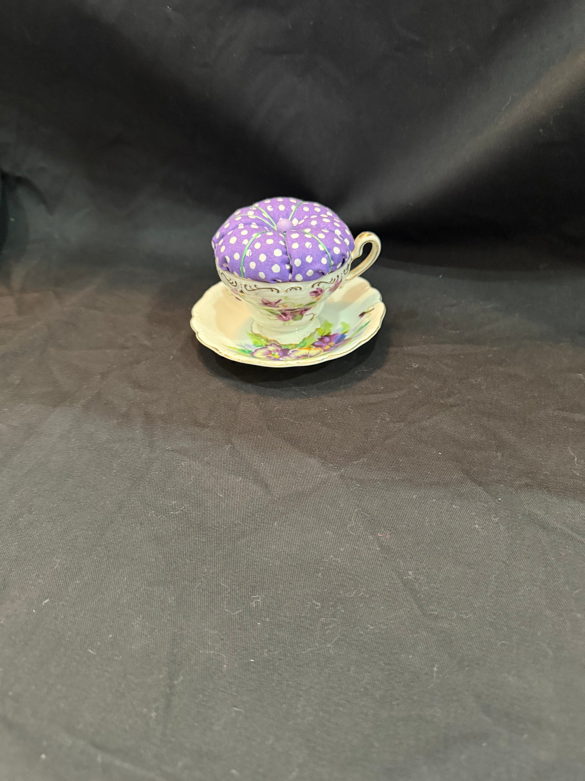 "Handmade quilted pin cushion with decorative fabric and secure pin storage"
