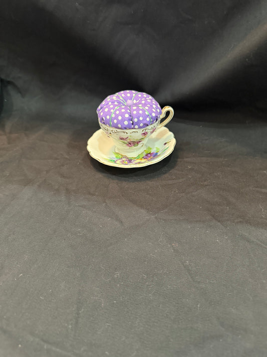"Handmade quilted pin cushion with decorative fabric and secure pin storage"
