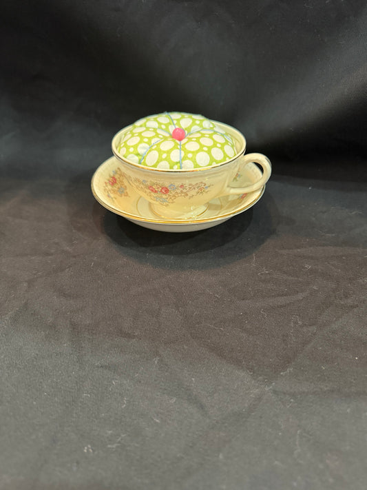 "Handmade quilted pin cushion with decorative fabric and secure pin storage"
