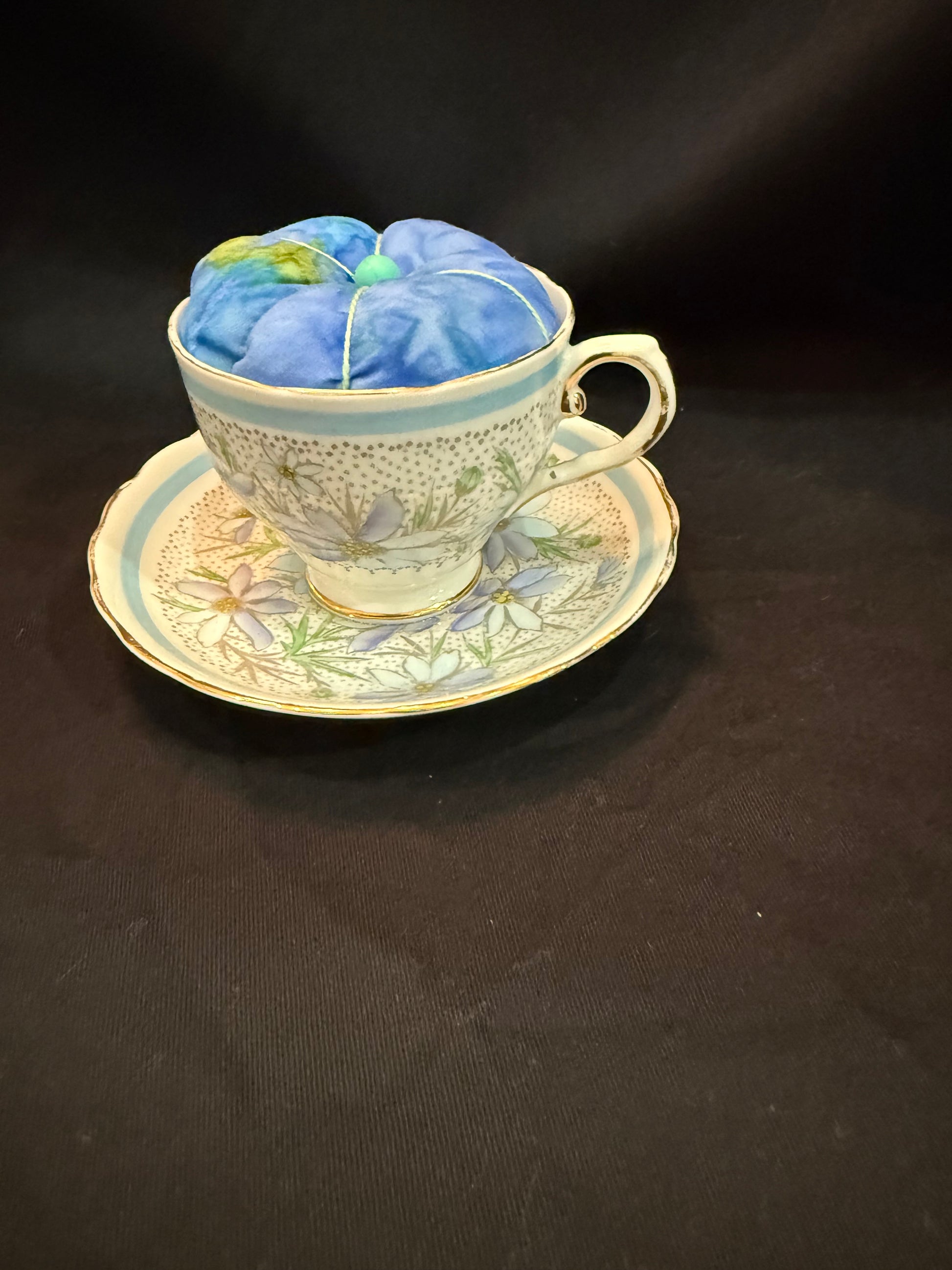 "Handmade quilted pin cushion with decorative fabric and secure pin storage"
