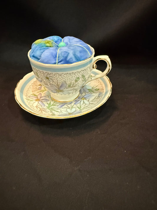 "Handmade quilted pin cushion with decorative fabric and secure pin storage"
